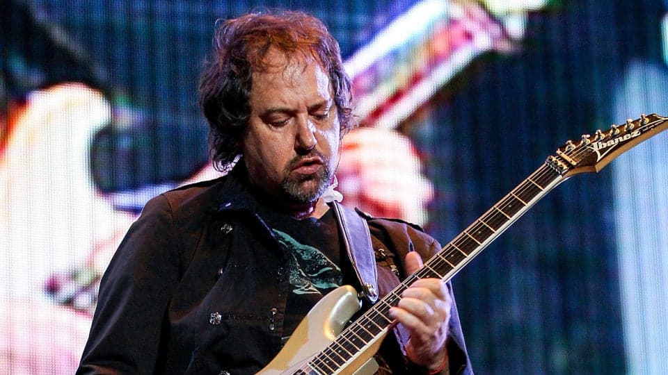 Músico Alejandro Marcovich tocando la guitarra en un concierto, reconocido por su trabajo en Caifanes, en un momento de actuación.