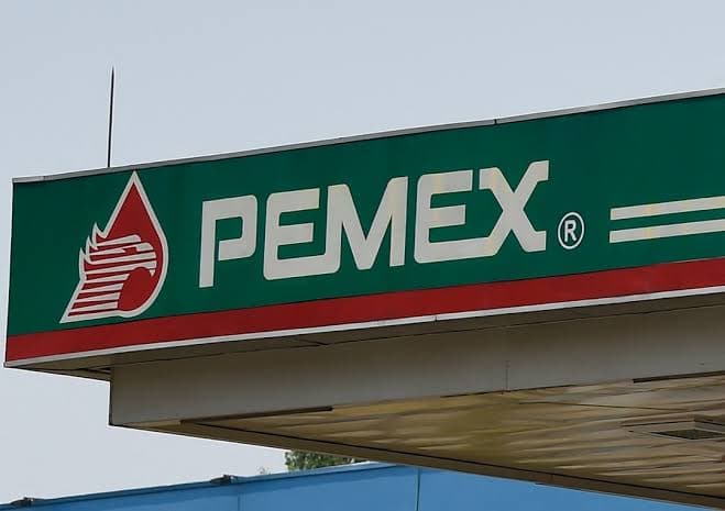 Logo de Pemex en una estación de servicio, simbolizando la estabilidad financiera y la reciente mejora en su calificación crediticia.