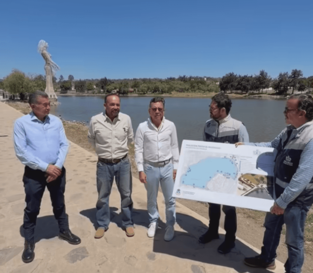 Pablo Lemus Navarro presenta el proyecto del Malecón en la Presa El Ocotillo, junto a funcionarios, con el agua de fondo.