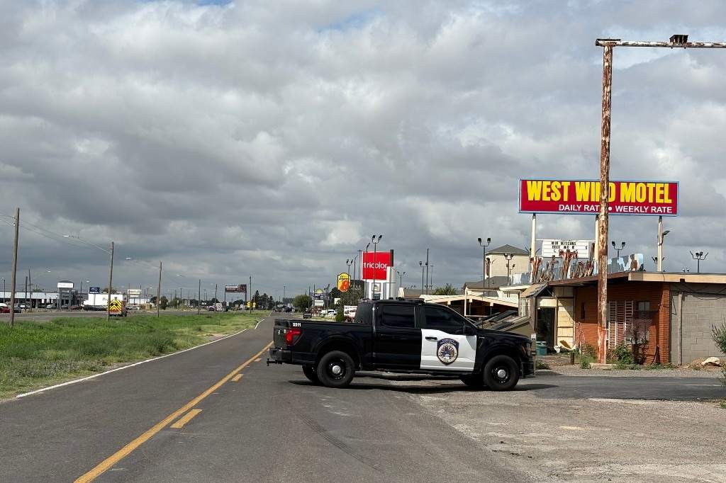 Vehículo policial bloquea la carretera frente al West Wind Motel en Midland, Texas, tras el tiroteo que dejó un muerto y varios heridos.
