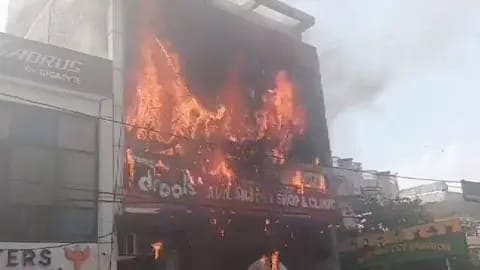 Incendio devastador en un edificio de tres niveles en Lucknow, India, con llamas intensas que consumen la estructura.