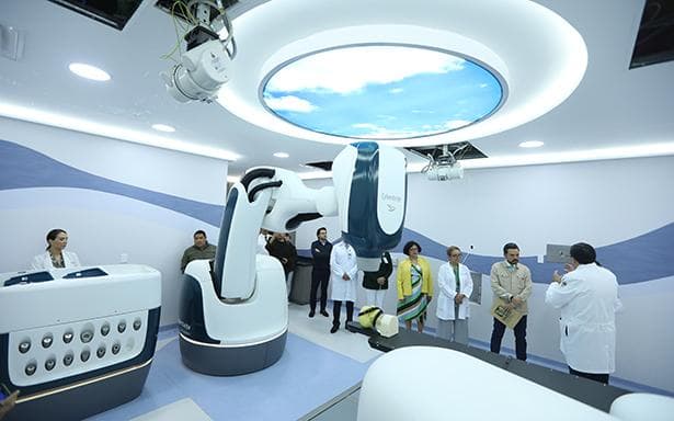 Sala de tratamiento del IMSS con tecnología avanzada para el tratamiento de melanoma ocular, médicos y personal observando el equipo.