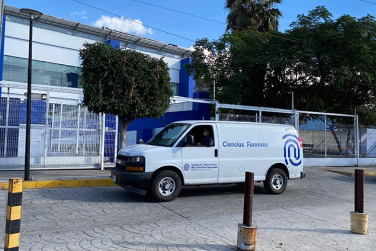 Furgón de Ciencias Forenses frente a un edificio, relacionado con la identificación de personas en Jalisco.