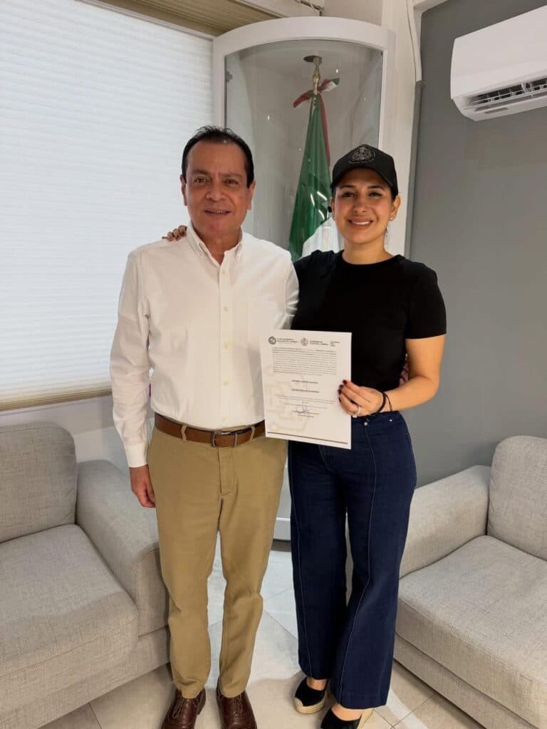 Estefanía Mercado y Arturo Castro posan juntos con el documento de designación como Secretario de Gobierno en Playa del Carmen.