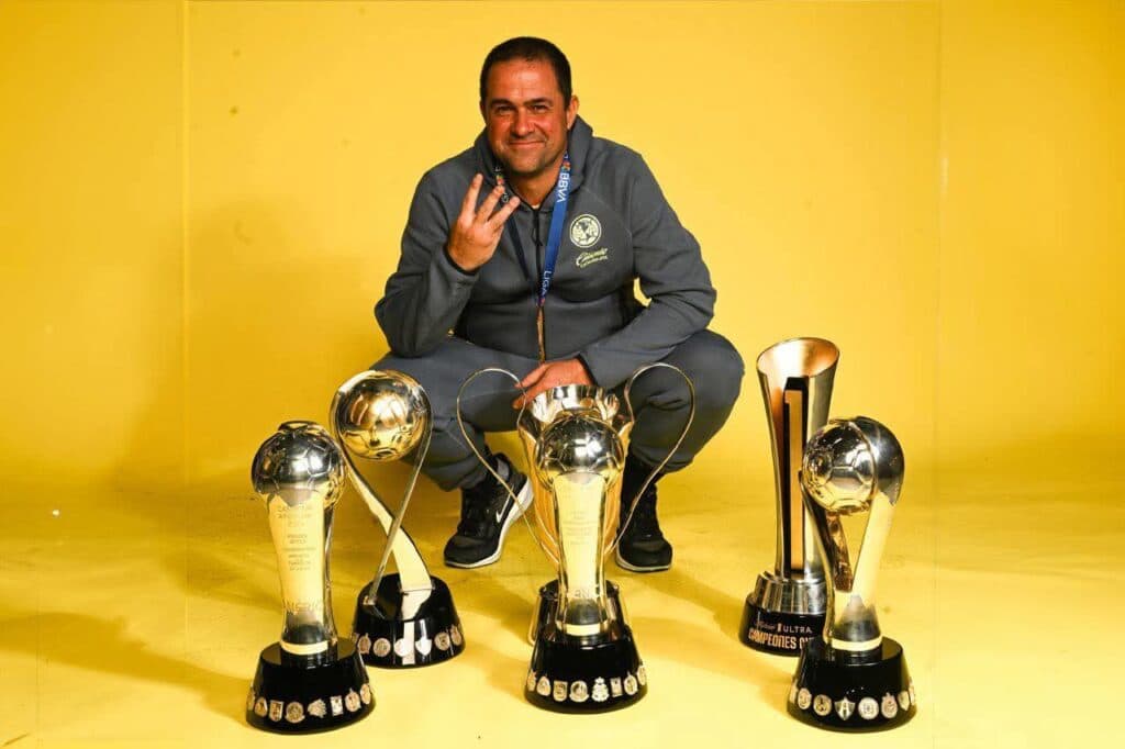 André Jardine se despide del Club América, posando con tres trofeos ganados durante su gestión como técnico.