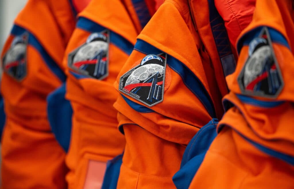 Uniformes de astronautas de la misión Artemis III, con parches que representan la exploración lunar y la NASA.