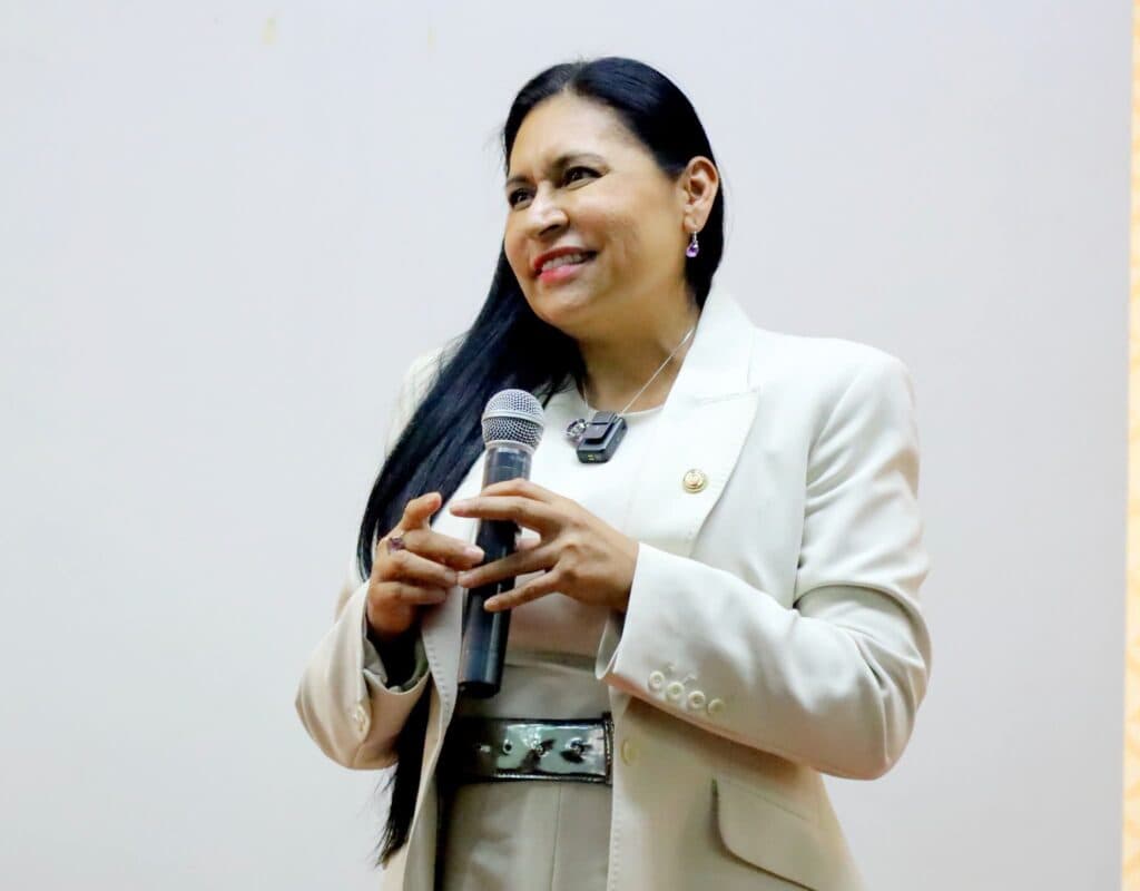 Ana Lilia Rivera, senadora de Morena, sonríe mientras sostiene un micrófono durante su informe de actividades legislativas en Tlaxcala.