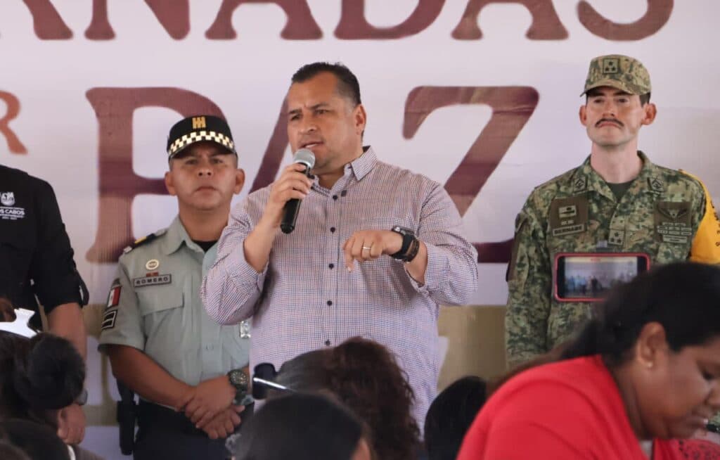 Saúl González Núñez habla en un evento sobre paz social en Baja California Sur, acompañado por autoridades y personal militar.