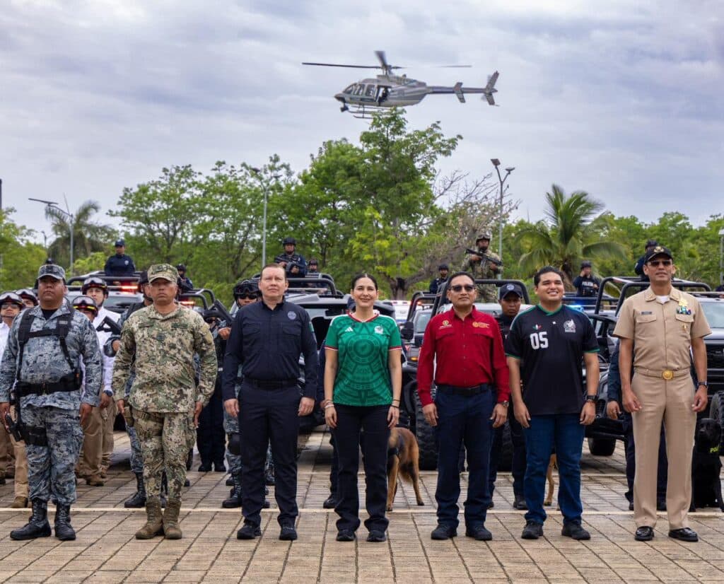 Estefanía Mercado y autoridades de seguridad posan frente a vehículos y un helicóptero durante el inicio del Operativo de