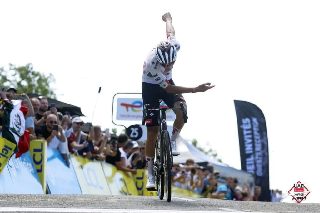 Isaac del Toro celebra su victoria en el Tour Auvergne-Rhône-Alpes 2026, levantando el brazo en señal de triunfo.