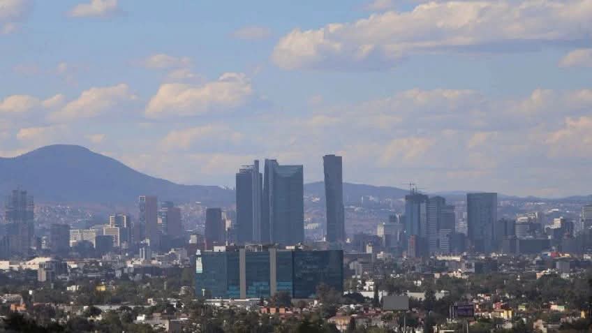 Vista panorámica de la Zona Metropolitana del Valle de México, destacando edificios y montañas bajo un cielo nublado.