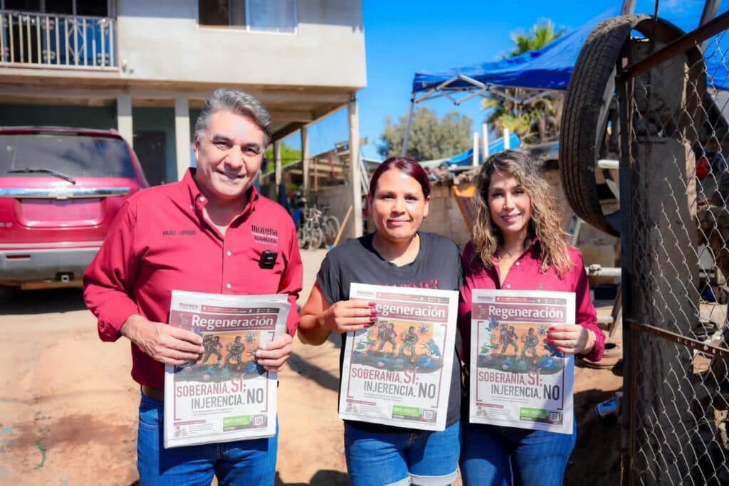 Jesús Ruiz Uribe, junto a su esposa Marcela Valdez y una residente, sostienen el órgano de difusión "Regeneración" en Ensenada.