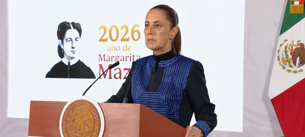 Claudia Sheinbaum durante conferencia matutina, cuestionando el regreso de Rubén Rocha Moya a Sinaloa, con fondo de la bandera mexicana.