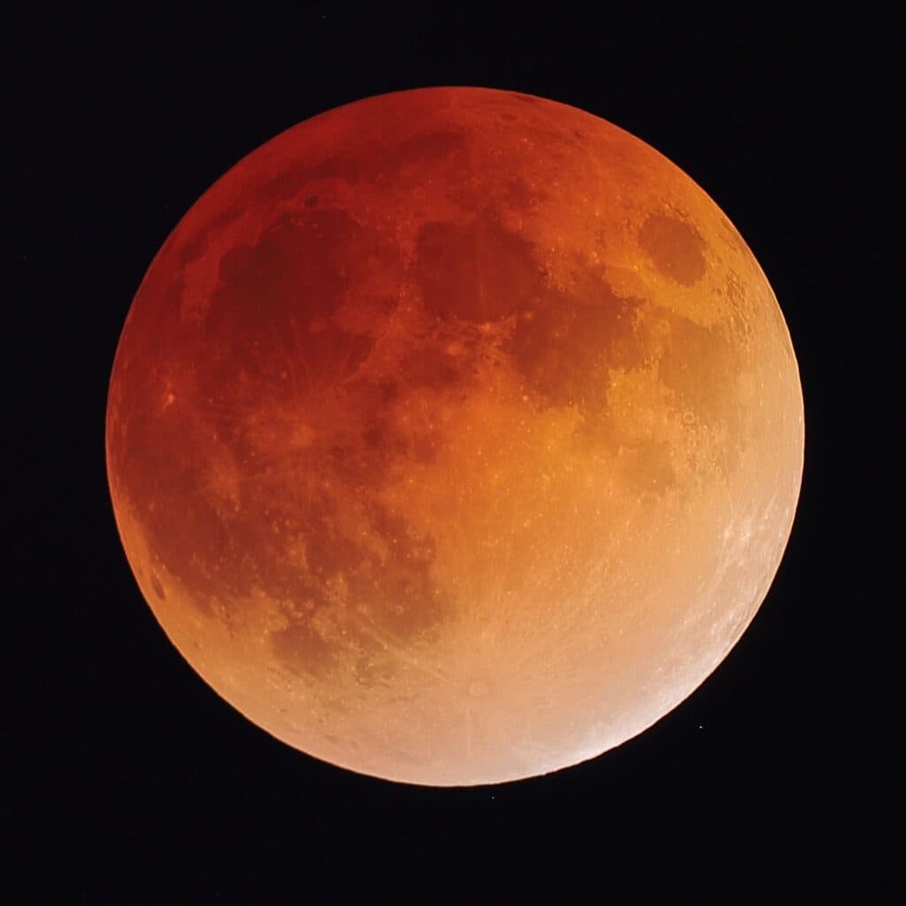 Luna llena con tonalidades rojizas y anaranjadas durante un eclipse lunar, fenómeno astronómico visible en México.