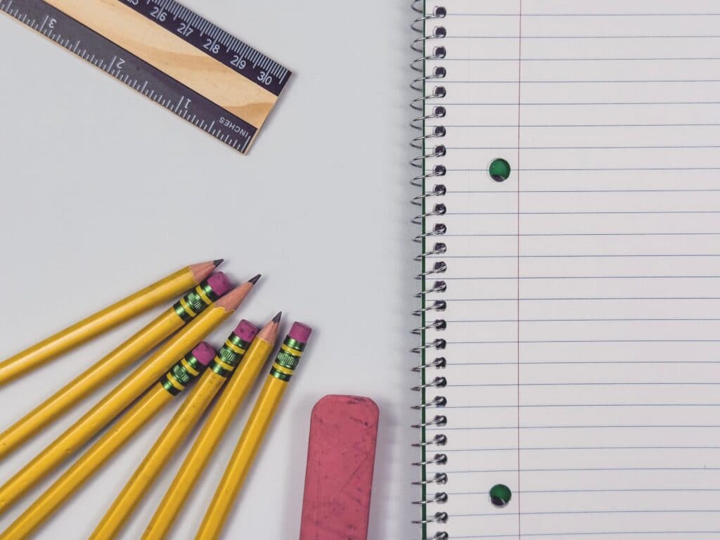 Útiles escolares como lápices, una regla y un cuaderno en un escritorio, reflejando la preparación para el regreso a clases en México.