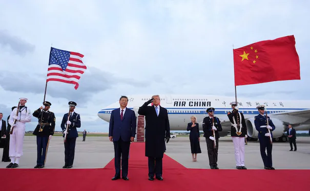 Trump y Xi Jinping en la base aérea Andrews, saludando con banderas de EE. UU. y China, durante la recepción oficial en Washington.