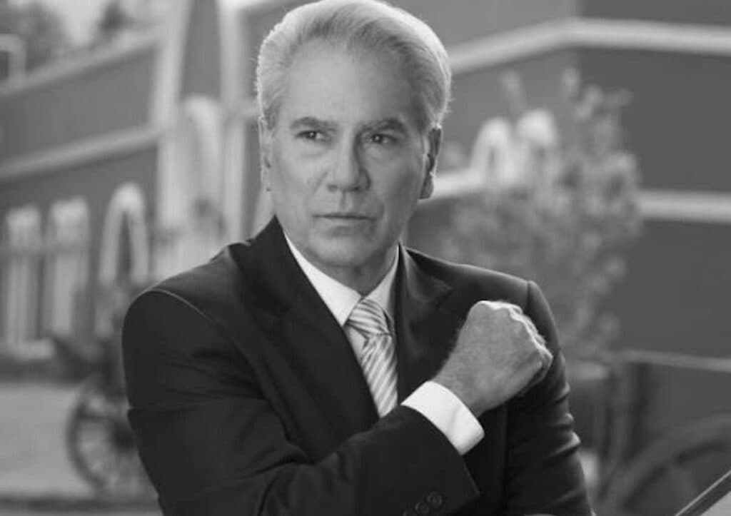Otto Sirgo en un retrato en blanco y negro, con traje y corbata, mostrando una expresión seria y reflexiva.