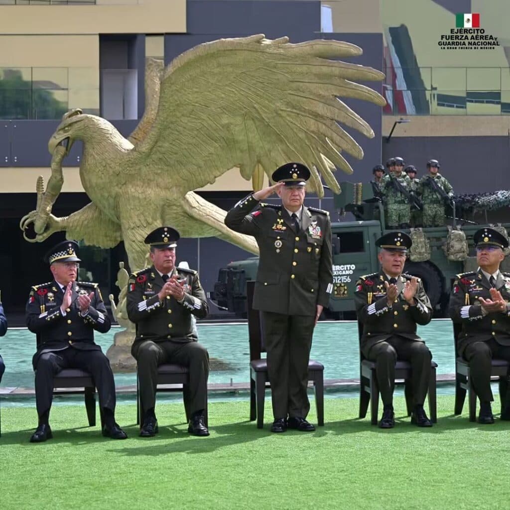 Ceremonia del 205 aniversario de la Sedena, con el general Trevilla realizando un saludo militar frente a altos mandos y un águila monumental.