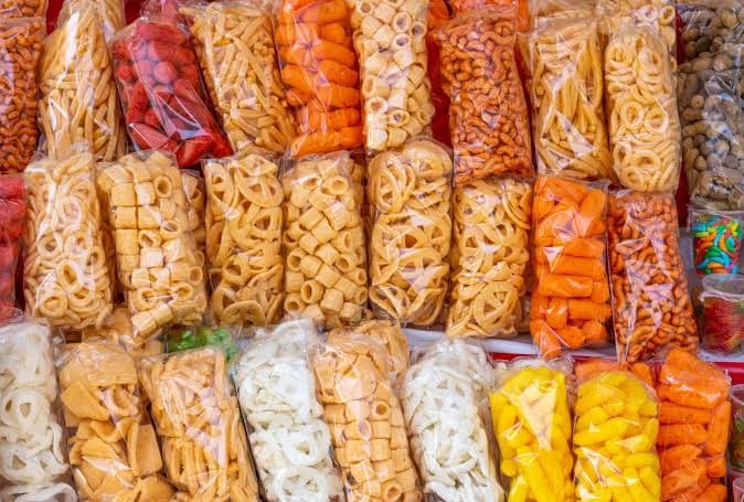Variedad de botanas en bolsas transparentes, representando la comida chatarra que será prohibida en escuelas y universidades de México.