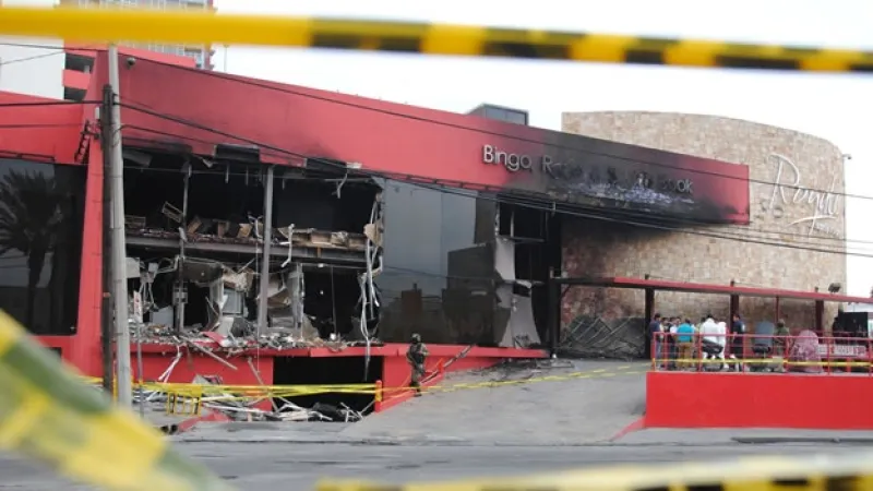 Edificio del Casino Royale en Monterrey con daños visibles tras el ataque incendiario, rodeado de cintas de seguridad.